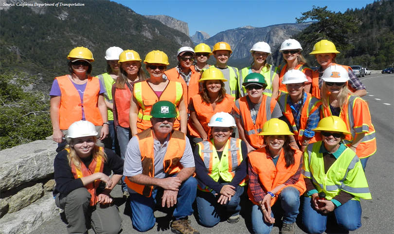 group photo of CDOT team members alongside a curved road in the mountains