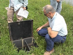 man crouched next to field equipment