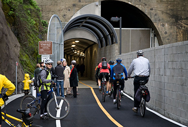 Photograph of four bicyclists riding into the Cal Park Hill Tunnel
