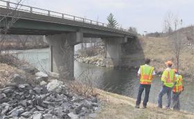 VTrans Bridge Program staff at a project site: a bridge over a river