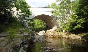 photo of a large, wide culvert under a concrete bridge