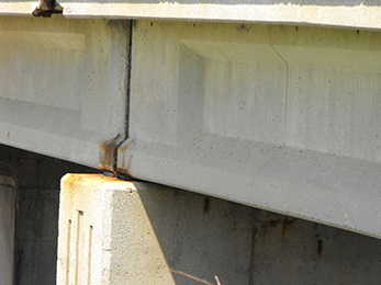 Photograph of the side of a bridge, showing rre-stressed concrete I-Beam