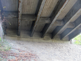 Photograph of the underside of a bridge, showing metal-rolled multi-beams