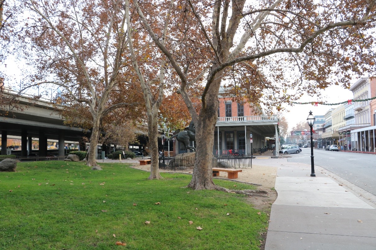 A photograph of a sideway in a retail area of Sacramento with a highway running behind the buildings.