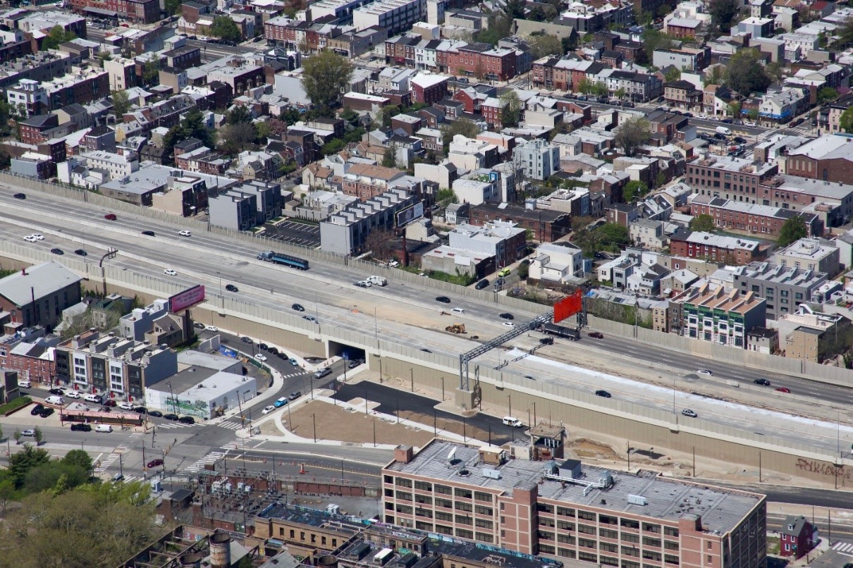 A bird's eye view of Philadelphia I-95 with buildings surrounding the highway.