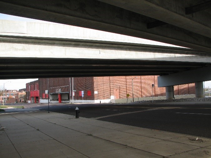 A photograph of a street view with two elevated highway roads running over the street below.