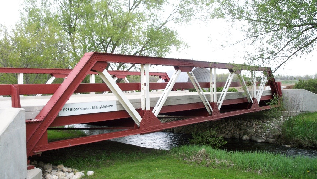 A photograph of a 1928 pony truss bridge spanning a waterway.