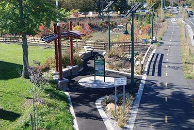 Photograph of the new greenway stop, rain garden, information kiosk, and recharge basin adjacent to the Route 347 shared-use path