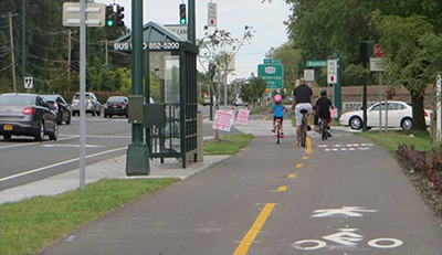Photograph of a family riding bicycles on the shared-use path beside Route 347 eastbound