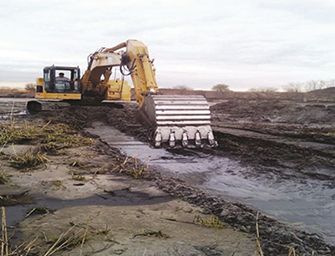 Photograph of a large backhoe at the Gerritsen Creek wetland restoration construction project
